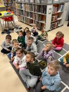 Pracownik biblioteki prezentuje dzieciom książki