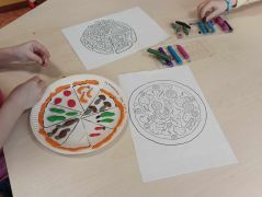 Dziecko tworzy swoją ulubioną pizze z różnych składników.