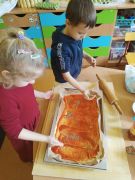 Dzieci przygotowują pizzę.