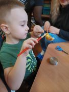 Chłopiec maluje jajako.