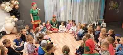 grupa dzieci siedzi w kole wraz z elfami