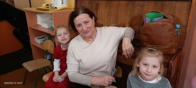 dwie dziewczynki siedzą wraz z babcią