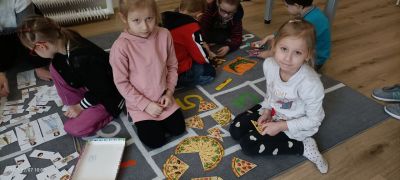 dzieci mają papierową pizze pociętą na kawałki