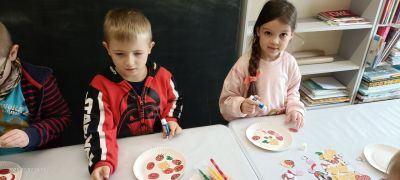 chłopiec i dziewczynka robią pracę plastyczną- pizza