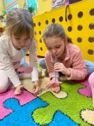 dziewczynki słomką zasysają papierowe serduszko 