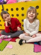 uśmiechnięte dziewczynki siedzą na dywanie