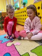 uśmiechnięte dziewczynki siedzą na dywanie