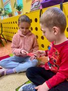 chłopiec podaje dziewczynce  papierowe serce klamerką