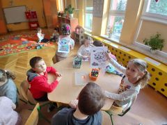dzieci wykonują przy stoliku karty pracy