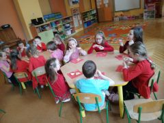 dzieci jedzą gofry siedząc przy stole