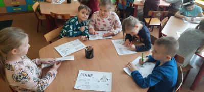 dzieci przy stoliku wykonują karty pracy