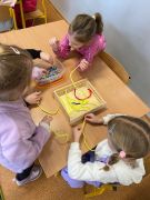 dziewczynki nawlekają koraliki na drucik