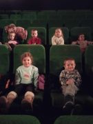 dzieci siedzą na fotelach w kinie