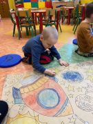 chłopiec koloruje rakietę