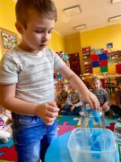 chłopiec wrzuca do pojemnika bibułę