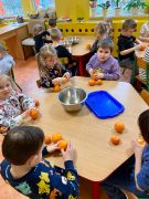 dzieci obierają mandarynki i pomarańcze