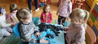 dziewczynki sprawdzają zawartość rękawicy wypełnionej różnymi surowcami
