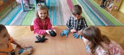 dzieci przy stoliku dotykają rękawic 