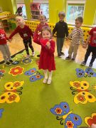 dzieci stoją w kole, jedna dziewczynka na środku z sercem w ręku