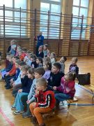 dzieci siedzą na widowni oglądając występ