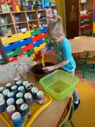 dziewczynka wsypuje ziemię do doniczki