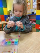 Dziewczynka wykonuje bransoletkę