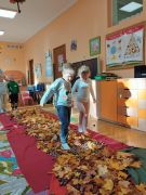 Dzieci przechodzą po ścieżce sensorycznej.