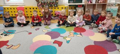 Dzieci siedzą na dywanie i słuchają Pani Ratownik