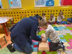 Chłopiec uczy się masażu serca na fantomie.