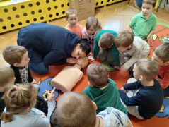 Dzieci obserwują jak udziela się pierwszej pomocy.