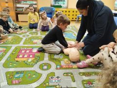 Chłopiec uczy się masażu serca na fantomie.