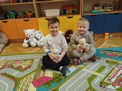 Chłopcy pozują do zdjęcia ze swoimi misiami.