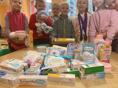 Dzieci prezentują produkty zebrane podczas zbiórki dla wcześniaków