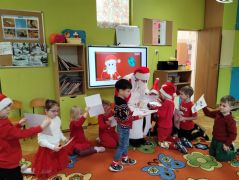 Dzieci wrzucają swoje listy do worka Mikołaja.