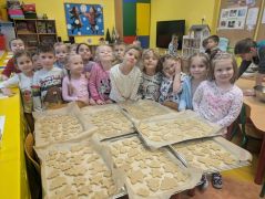 Dzieci pozują do zdjęcia z pierniczkami.