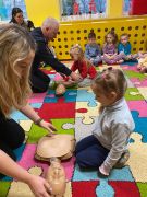 Dzieci wykonują resuscytację na manekinie pod okiem Państwa ze Straży  Miejskiej.