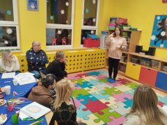 Pani prowadząca tłumaczy zadanie rodzicom.