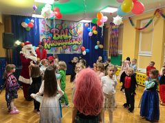 Dzieci tańczą z Mikołajem.