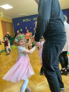 Dzieci tańczą z rodzicami do muzyki.