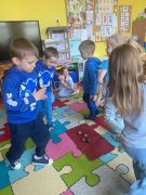 Dzieci tańczą na dywanie.