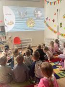 Dzieci oglądają prezentację multimedialną.